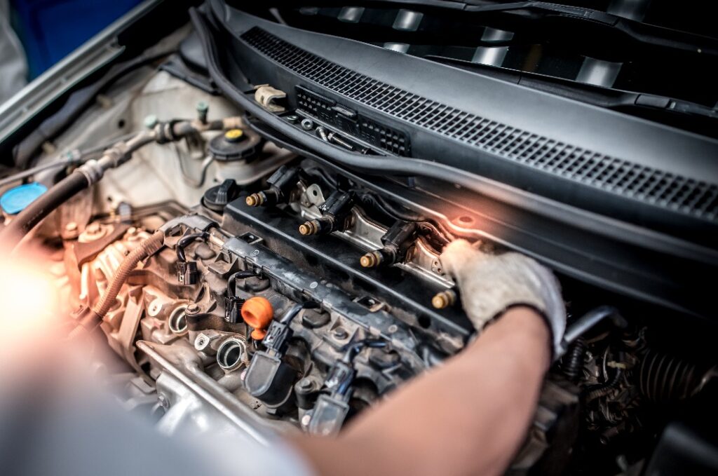 Kfz-Mechaniker überprüfen die Einspritzsysteme von Fahrzeugen mithilfe von Diagnose- und Reparaturwerkzeugen im Motorraum.