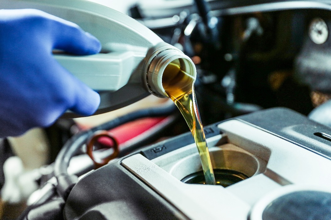 Nahaufnahme: Motoröl wird in den Motor eingefüllt. Einfüllen von neuem Öl in den Motor. Ölwechsel am Automotor