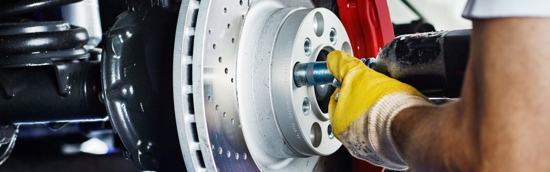 Car mechanic in a garage repairs a bracke