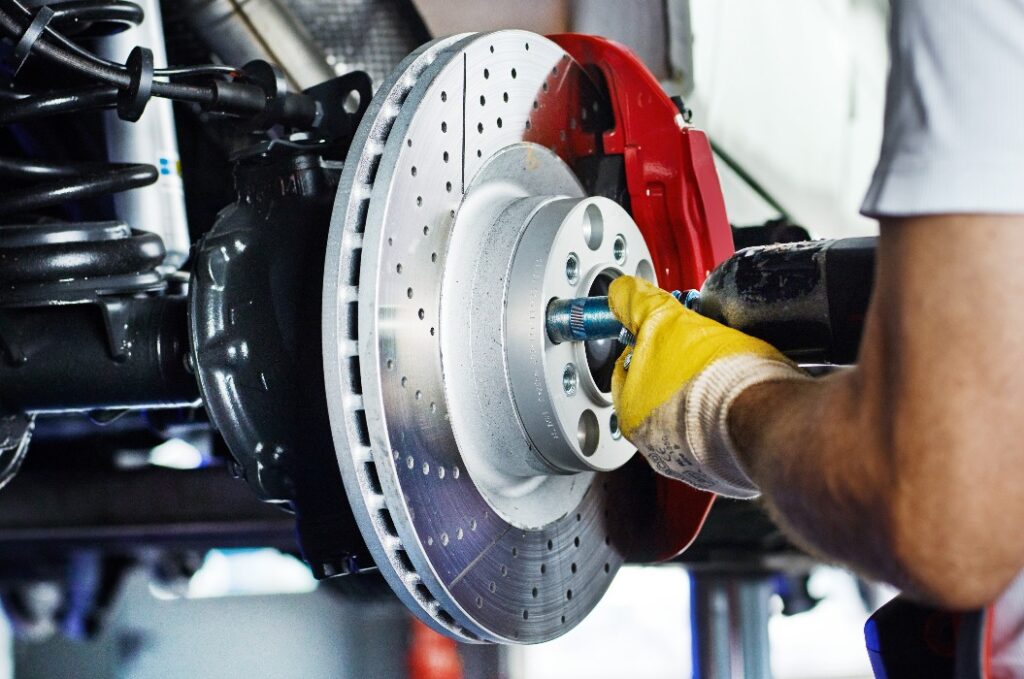 Car mechanic in a garage repairs a bracke