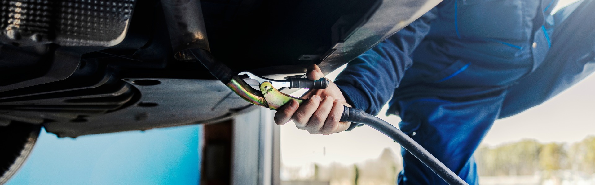 Close up of a auto mechanic measuring exhaust gases on a car at workshop.